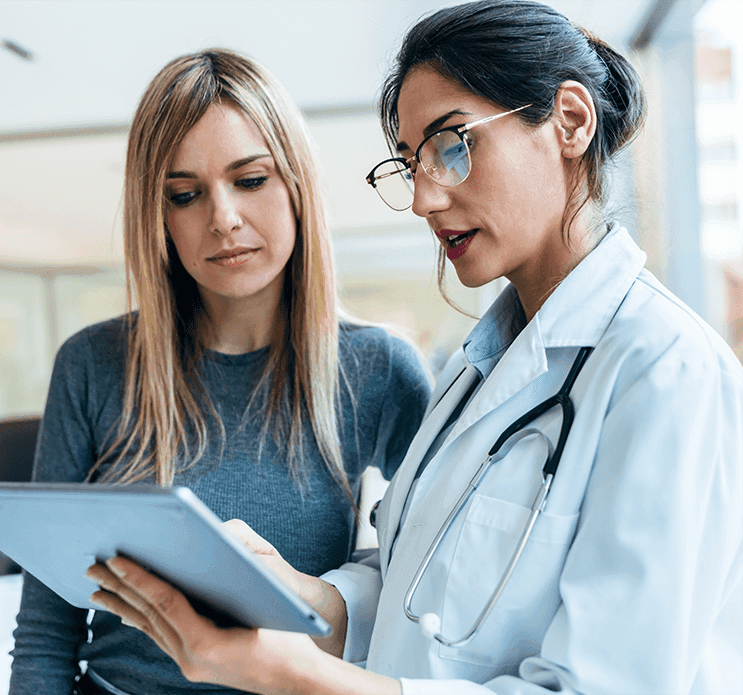 A clinician reviewing a tablet with a patient